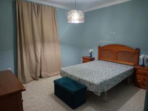 a bedroom with a bed and a chair and a lamp at El Rincón de Doñana in Villamanrique de la Condesa
