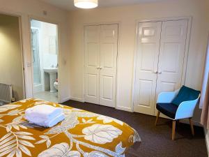 a bedroom with a bed and a blue chair at Johnson Townhouse in Wellingborough +10 photos