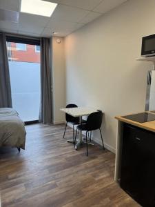a room with a bed and a table and chairs at Logement centre-ville Muret in Muret