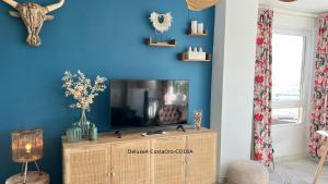 a living room with a tv and a blue wall at CostaOro in Torrox Costa +55 photos