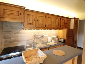 a kitchen with wooden cabinets and a sink and a counter at Appartement cosy près du centre et des pistes avec balcon, parking, 6 couchages - FR-1-623-305 in Les Gets
