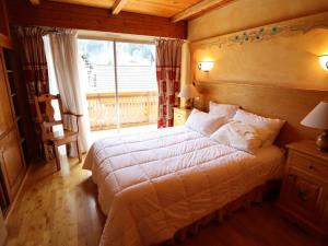 a bedroom with a large bed and a large window at Appartement cosy près du centre et des pistes avec balcon, parking, 6 couchages - FR-1-623-305 in Les Gets