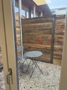 a table and a chair in front of a fence at Appartement avec extérieur in Muret