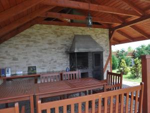 taras zewnętrzny z grillem i drewnianym pokładem w obiekcie Modern holiday homes for 8 people with the pool w mieście Kołczewo