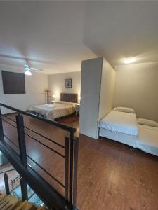 ein Hotelzimmer mit zwei Betten und einer Treppe in der Unterkunft Duplex temporario Santa Fe in Santa Fe