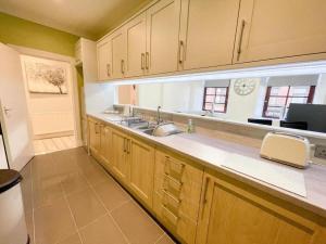 グラスゴーにある2 Bed apartment in city centre!の大きなキッチン(木製キャビネット、シンク付)