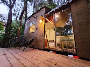 Cabaña pequeña con mesa y sillas en una terraza en Tiny House da serra perto de São Paulo em meio a natureza, en Mairiporã