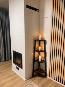 a living room with a fireplace and a shelf with candles at Northern Star Apartment 4 in Ivalo