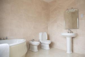 a bathroom with a tub and a toilet and a sink at Tara Manor - Family gathering's & hen parties in Omagh +22 photos
