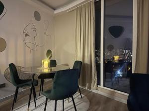 a dining room with a table and chairs and a window at Sky Lux Point in Skopje
