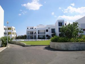 ein großes weißes Gebäude mit einem Park davor in der Unterkunft San Rocco one bed Apartments 4A1 9 in Isca sullo Ionio