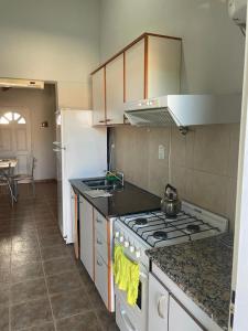 una cucina con fornelli e frigorifero di Costa magica a Las Grutas