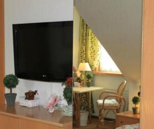 a living room with a flat screen tv on a wall at Hotel Grüner Baum in Stollberg