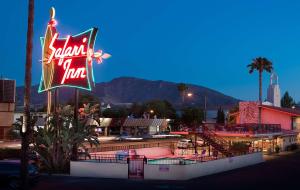 a sign for arizolis motel with mountains in the background at Safari Inn Burbank-Universal, a Coast Hotel in Burbank
