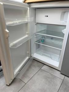 an empty refrigerator with its door open in a kitchen at Freundliches City-Apartment mit Balkon & Skyline-Blick - Easy Stay Wuppertal in Wuppertal
