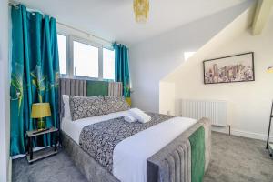 a bedroom with a large bed with blue curtains at -75CR- Setup for your most relaxed and amazing stay in Leeds +44 photos