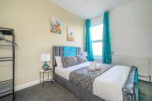 a bedroom with a bed with blue curtains at -75CR- Setup for your most relaxed and amazing stay in Leeds