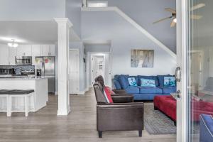 a living room with a blue couch and a kitchen at SeaSide by Oak Island Accommodations in Oak Island