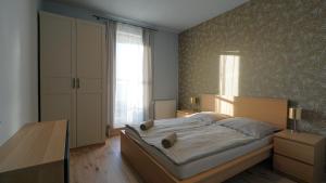 a bedroom with a large bed with a wooden headboard at Club218 Wellness Apartments in Siófok +36 photos