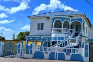 a blue and white house with a gate at St Thomas Oasis in Lyssons
