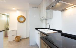 a white kitchen with a sink and a mirror at 1 Bedroom Lovely Apartment In Denia in Denia