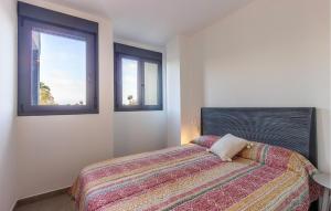 a bedroom with a bed and two windows at 1 Bedroom Lovely Apartment In Denia in Denia
