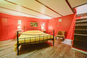 een slaapkamer met rode muren en een bed en een stoel bij Amelie in Paris in Parijs