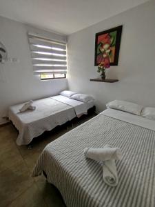 a bedroom with two beds and a window at Descanso cafetero apartasol Tebaida in La Tebaida