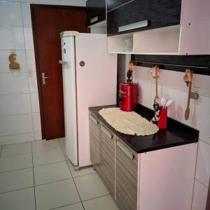 cocina con nevera blanca y encimera en Casa de praia meu bom, en Rio das Ostras