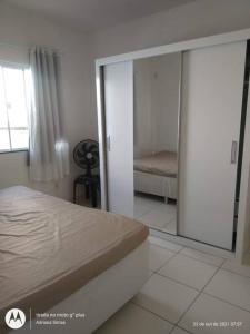 1 dormitorio con cama y puerta de cristal con espejo en Casa de praia meu bom, en Rio das Ostras