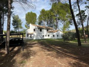 una casa bianca con un'auto parcheggiata davanti di Casa del Cura a Calasparra
