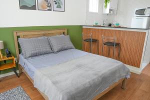 a bed in a room with a counter and a kitchen at Flat encantador no Centro do Rio de Janeiro in Rio de Janeiro