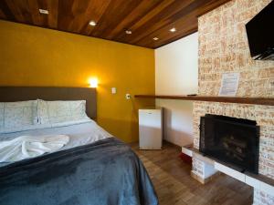 una camera da letto con un letto e un camino di Pousada Natureza da Terra a Monte Verde