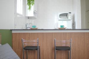 two chairs sitting at a bar in a kitchen at Flat encantador no Centro do Rio de Janeiro in Rio de Janeiro