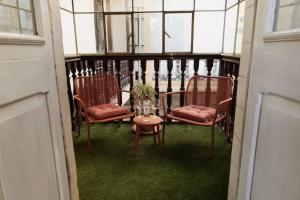 a balcony with two chairs and a table with a glass table at La Casona Consuelo in Arequipa