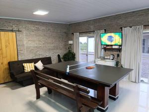 a ping pong table in a living room with a couch at Chacra LANATIVA in Poblado Echeverry +10 photos