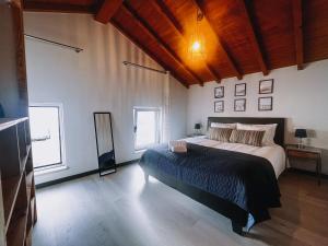 Un dormitorio con una cama grande y dos ventanas. en Casinha Praia Azul, en Costa de Lavos 15 fotos más