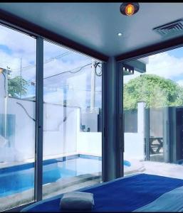 a bedroom with a view of a swimming pool through windows at Cancún Hotel Boutique & Hostel in Cancún