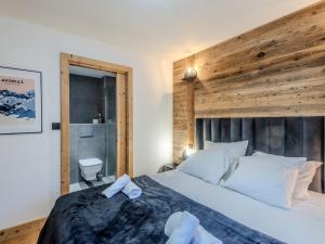 a bedroom with a large bed with a wooden wall at Chalet de charme rénové, centre Morzine, 4 pers, proche remontées mécaniques, parking inclus - FR-1-754-38 in Morzine