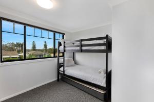 a bedroom with bunk beds and a large window at North Entrance Beach House in The Entrance