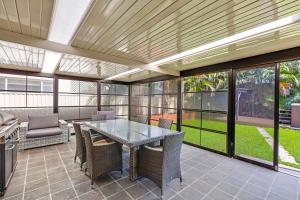 an outdoor patio with a glass table and chairs at North Entrance Beach House in The Entrance