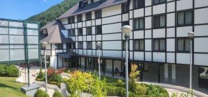 a building with a person sitting outside of it at Brzece lux apartman in Brzeće