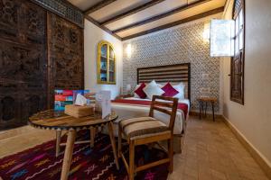 a bedroom with a bed with a table and a table sidx sidx sidx at Riad Nalan & Spa in Marrakech