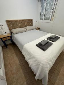 a bedroom with a large white bed with towels on it at El Playaiso de San José in San José