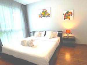 een slaapkamer met twee bedden en een raam bij Emerald Terrace Condo 42- 1 Bed Pool in Patong Beach