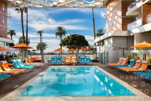 a pool at a hotel with chairs and umbrellas at Shore Hotel in Los Angeles