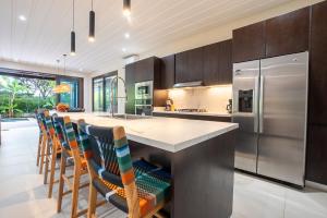 Una cocina con una gran isla con sillas de bar. en Villa Dunama, en Tamarindo