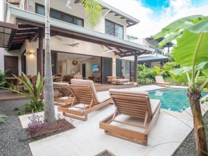 una imagen de un patio trasero con sillas y una piscina en Villa Dunama, en Tamarindo