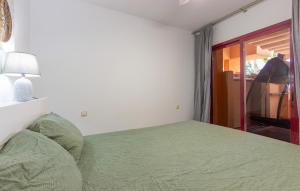 a bedroom with a green bed and a window at Beautiful Apartment In Los Alcazares in Los Alcázares