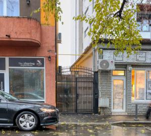 a black car parked on a city street with buildings at 2 Hidden Gems - all U need - by Uni88 in Bucharest